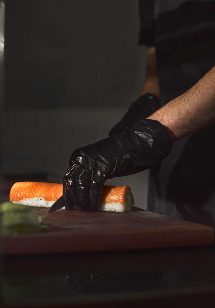 sushi-chef-slices-fresh-salmon-sushi-bar-chef-cutting-sushi-professional-kitchen-creative-work (1)